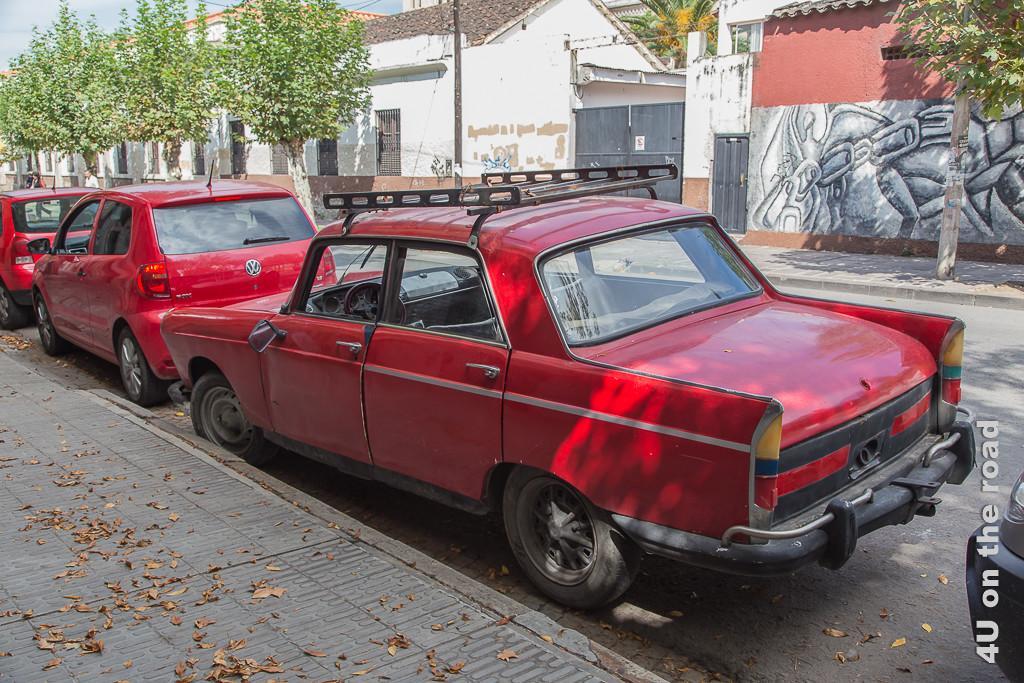 Bild Oldtimer sind alltäglich im Strassenbild von Salta, hier ein uraltes rotes Auto hinter einem modernen roten VW