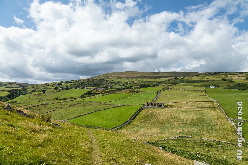Bild Blick vom Torr Head zeigt die von Mauern und Strassen durchzogene, ansteigende Landschaft mit Ruine.