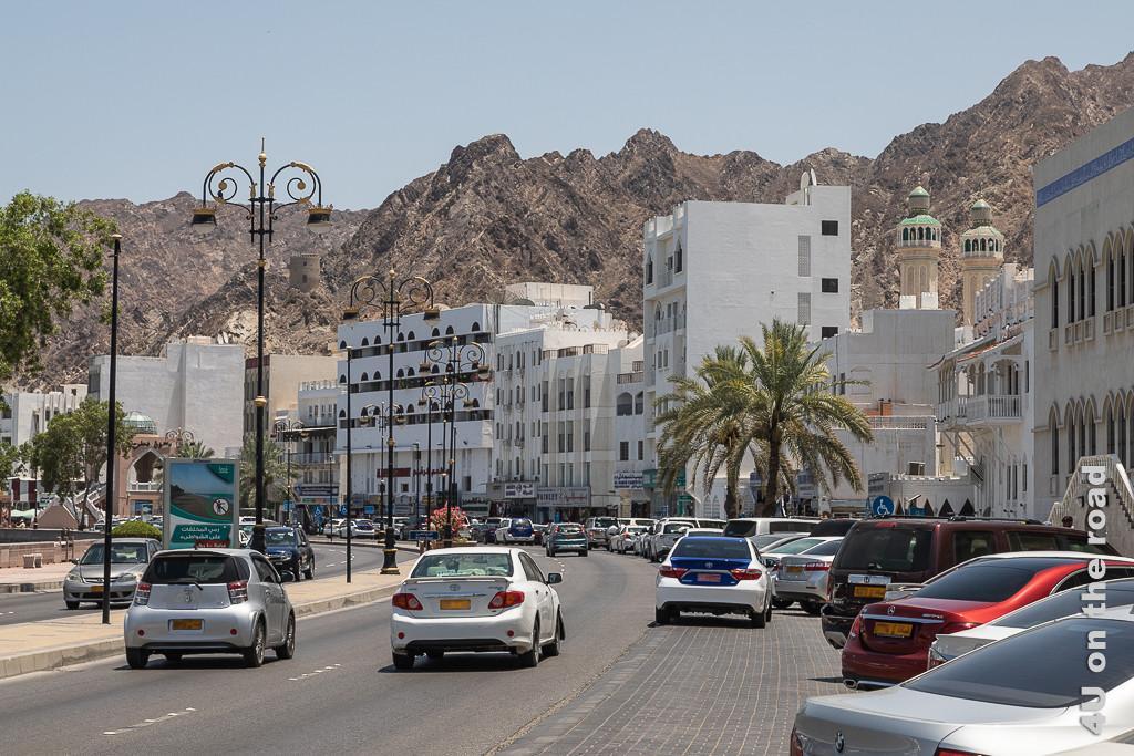 Muscat - Blick auf die Küstenstrasse Corniche rechts vom Fischkreisel. Zu sehen sind Wohn- und alte Handelshäuser vor der Kulisse der Berge