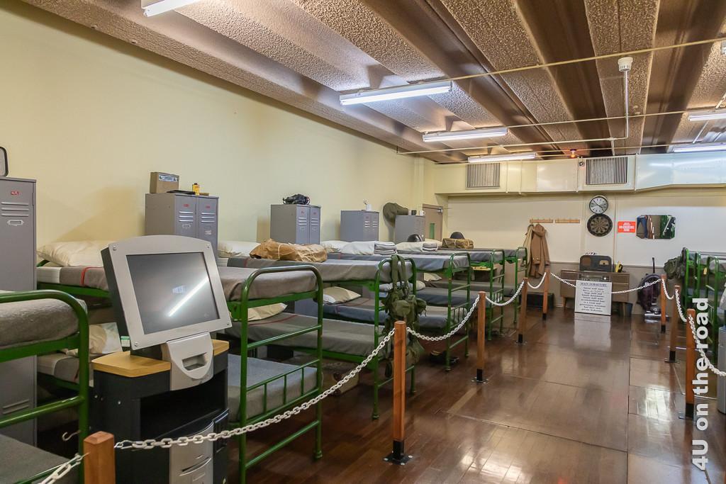 Schlafräume der normalen Angestellten Secret Bunker . Im Bild sieht man 6 Doppelstockbetten nebeneinander und vis-a-vis, getrennt durch Doppelspinde. Im Vordergrund steht ein uralter PC.