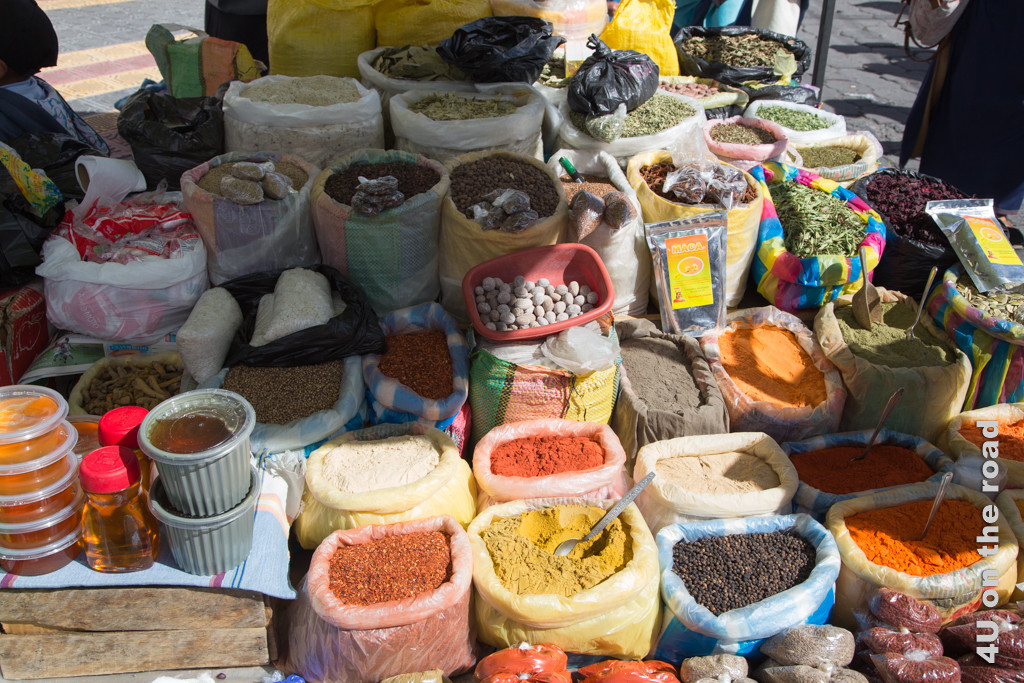 Bunte Gewürze liegen in offenen Säcken und warten auf Käufer. Samstagsmarkt in Otavalo