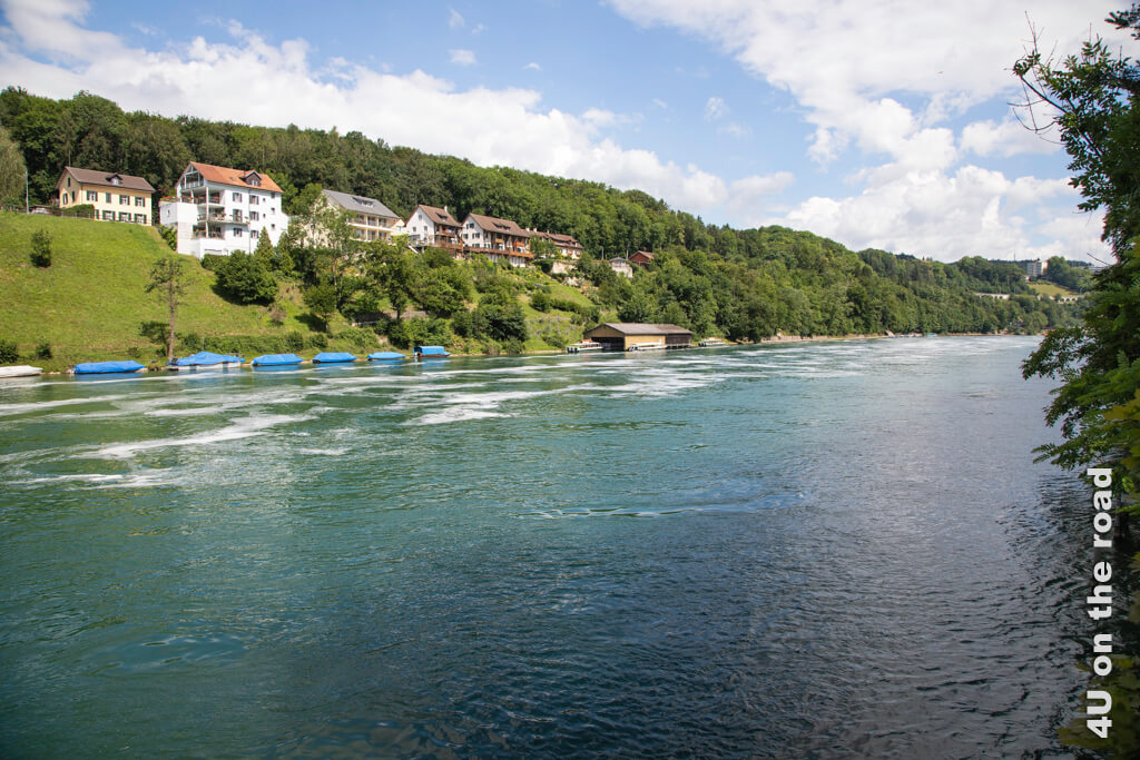 Die Nohlbrücke überqueren wir auf unserer Rundwanderung zum Rheinfall. Hier ist nichts mehr vom aufgewühlten Wasser zu sehen. Abgedeckte Boote parken am Ufer und Häuser stehen oben am Hang.
