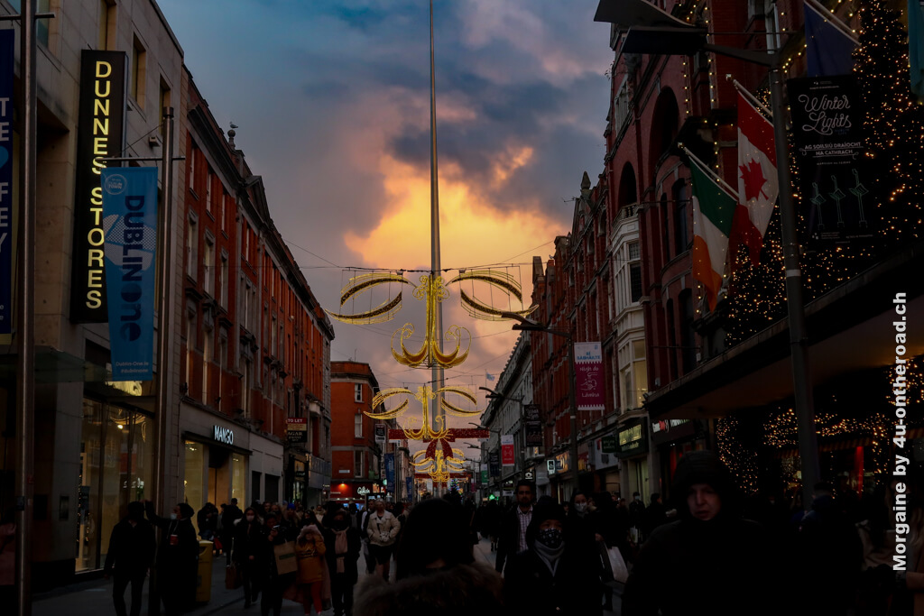 Die Spitze (The Spire) in Dublin vor dramatischem Himmel und leuchtender Weihnachtsdekoration - Weihnachten in Irland