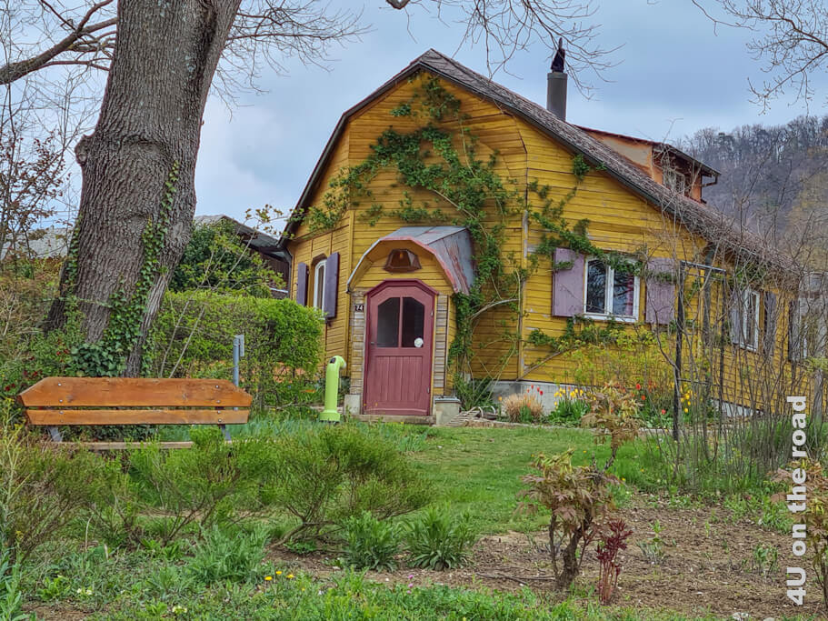 Das Gartenhaus neben dem Goetheanum besteht aus gelb gestrichenem Holz. Der Eingang erinnert ein wenig an den Bug eines Schiffes. Die Fenster haben alle altrosa Fensterläden. Der Hydrant im Garten ist hellgrün.  Ausflüge Schweiz im Frühling