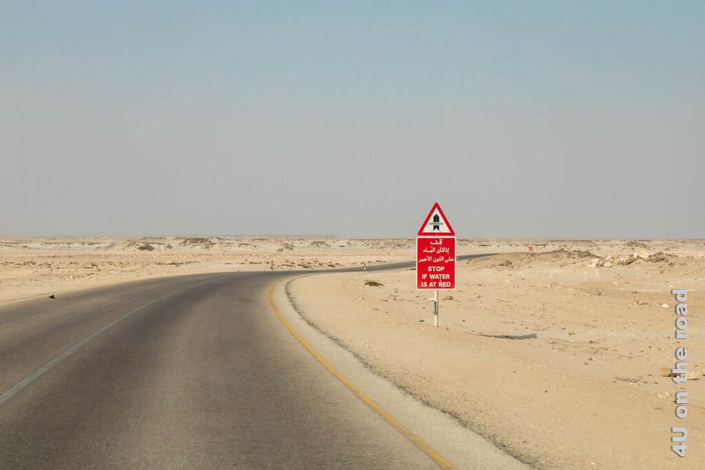 Pegelstandsanzeiger in der Wüste. Erreicht das Wasser das Schild, wird man aufgefordert zu warten bis das Wasser sinkt. Oman Reisetipps - Autofahren im Oman