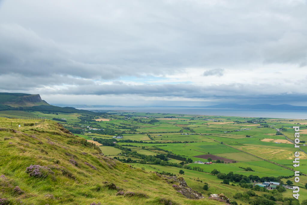 Vom Gortmore Viewpoint schaut man an klaren Tagen bis zur Westküste Schottlands. Bei unserem Besuch ist der Himmel sehr wolkig. Man sieht vor allem die vielen Felder, dass Meer und die steilen Klippen.