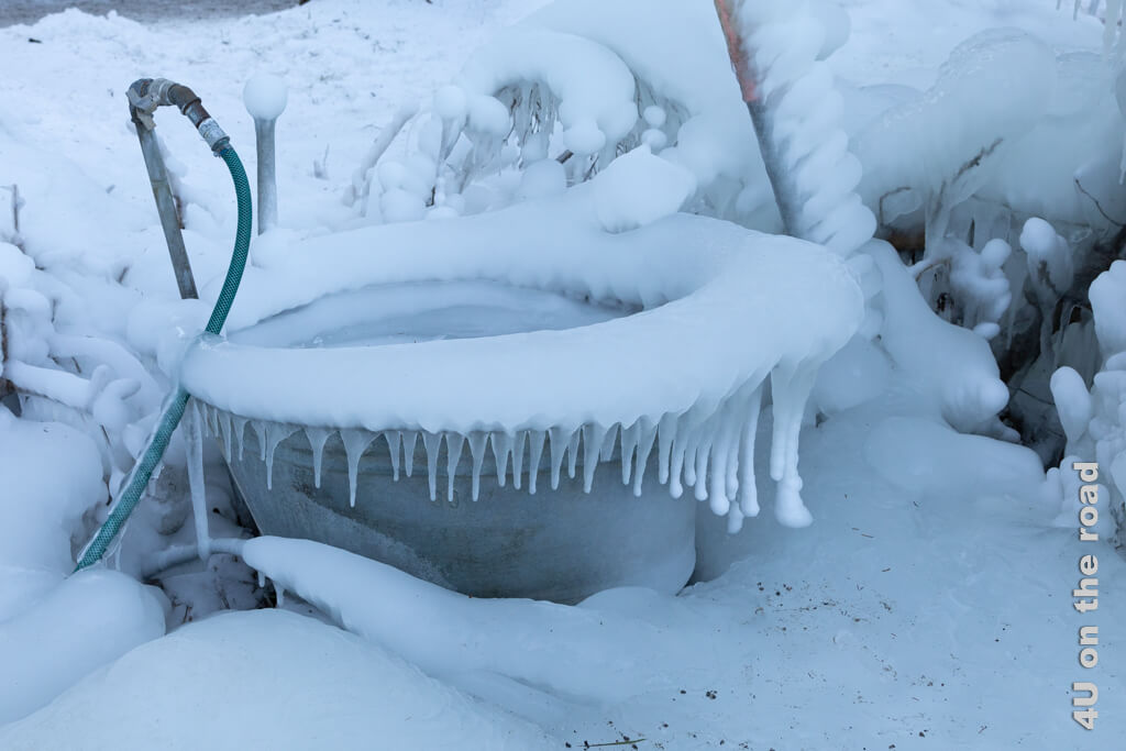 Ein Wasseranschluss mit einer Zinkwanne, deren Rand über und über mit Eis bedeckt ist und schöne Eiszapfen angesetzt hat. Ein Detail welches du bei den Eispalästen am Schwarzsee bewundern kannst.