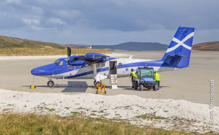 Eine kleine Propellermaschine steht am Strand von Barra und wird mit Gepäck beladen. Feature Anreise Schottland