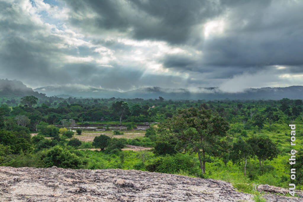Gebündelte Lichtstrahlen brechen durch tief hängende Wolken und lassen im Dunst Berge von üppiger Vegetation erahnen. Reisetipps Sri Lanka von A bis Z - Reisezeit