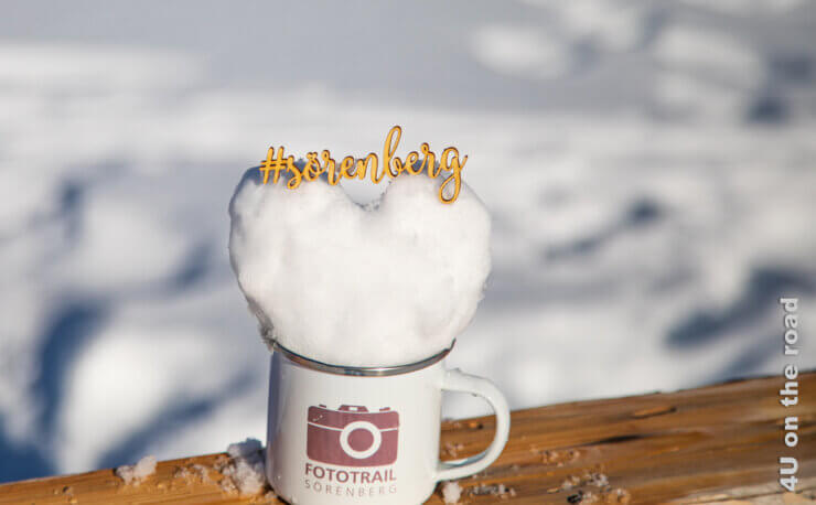 Eine Tasse mit der Aufschrift Fototrail, einem Schneeherz und dem Schriftzug Sörenberg sind das Feature Bild.
