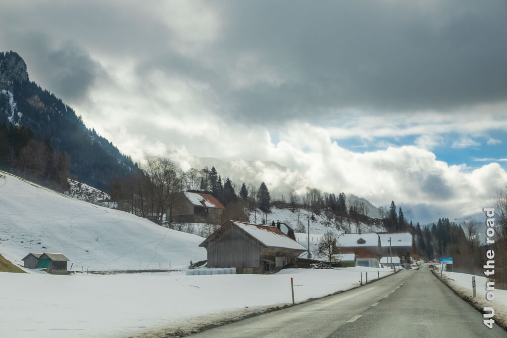 Auf der Strassen nach Sörenberg liegt kurz vor dem Ziel endlich Schnee. Die Wolken lassen die Berge in einer dramatischen Lichtstimmung ahnen.