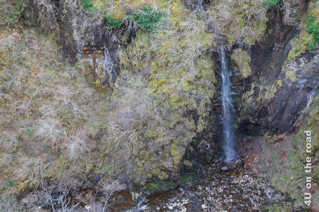 Noch haben die Büsche am Felsen keine Blätter, so dass man den bemoosten Untergrund erkennen kann. Der Wasserfall ist gerade nicht beeindruckend. Warum dies eine Sehenswürdigkeit auf der Isle of Skye mit zwei Parkplätzen ist, ist uns etwas unklar.