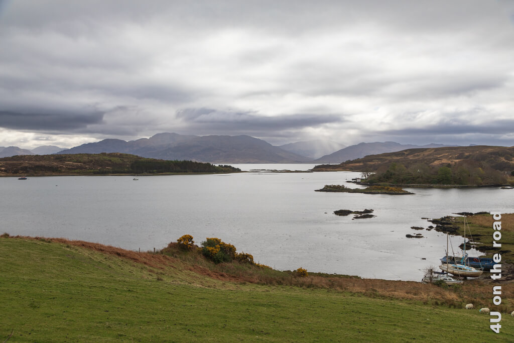 Blick auf die Gesto Bay mit Bergen und dicken Wolken, aus denen es teilweise örtlich sehr begrenzt regnet. Davon darf man sich auf der Isle of Skye nicht aufhalten lassen, die Highlights zu erkunden.