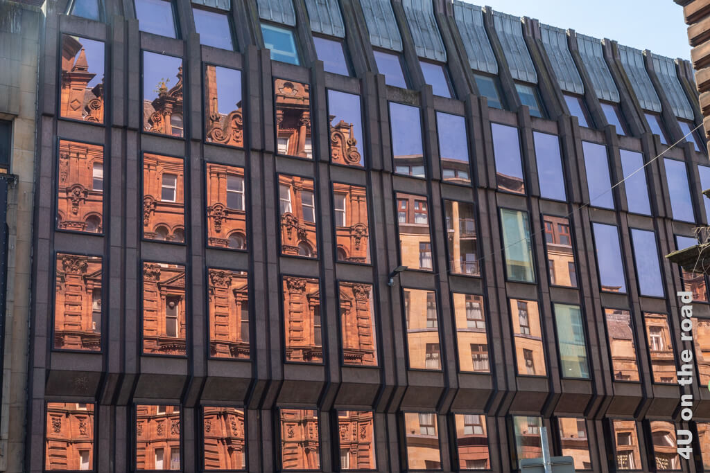 Alte Gebäude spiegeln sich in der modernen Glasfassade eines anderen Gebäudes. Ein Wochenende in Glasgow macht müde Füsse. Die Fotografie entstand auf dem Weg zur Nekropolis. 