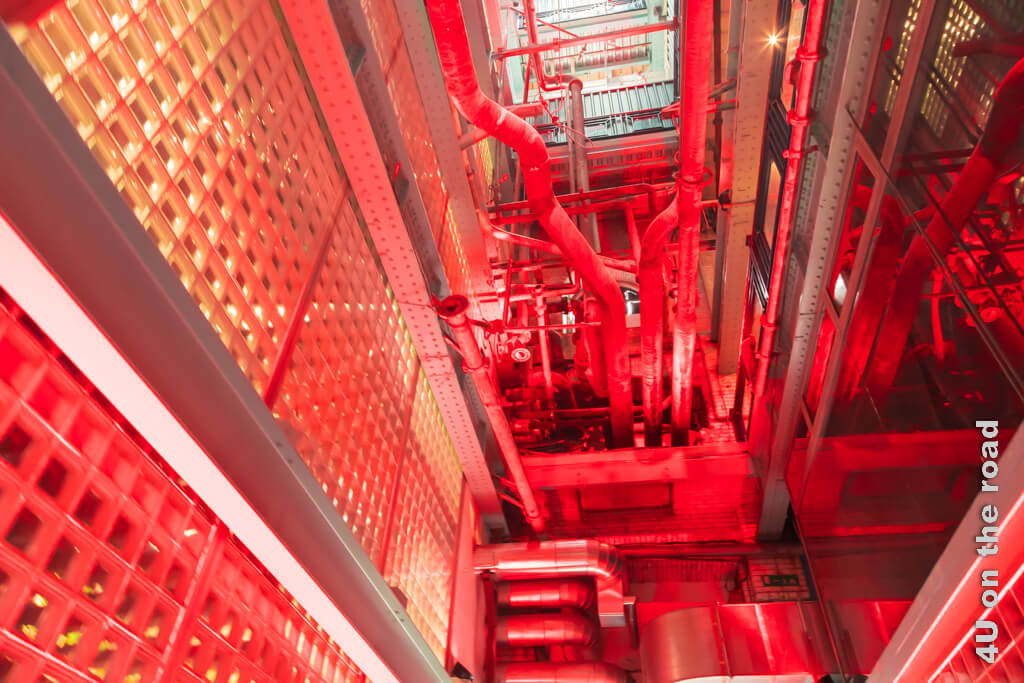 Hier führen die alten Rohre durch das Fabrikgebäude. So rot angestrahlt über mehrere Etagen, ist das sehr beeindruckend.