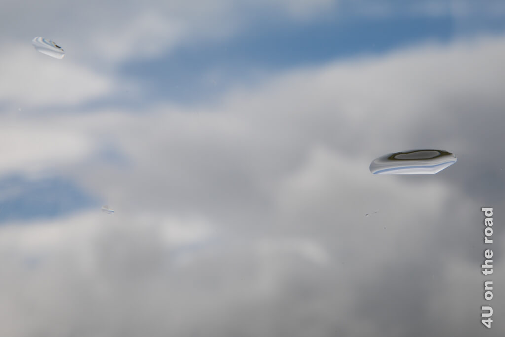 Ein Bild zeigt die Wetteroptionen während deines Urlaubs mit dem Hausboot: blauen Himmel, graue Wolken und Regentropfen mit Spiegelung des Szenarios.