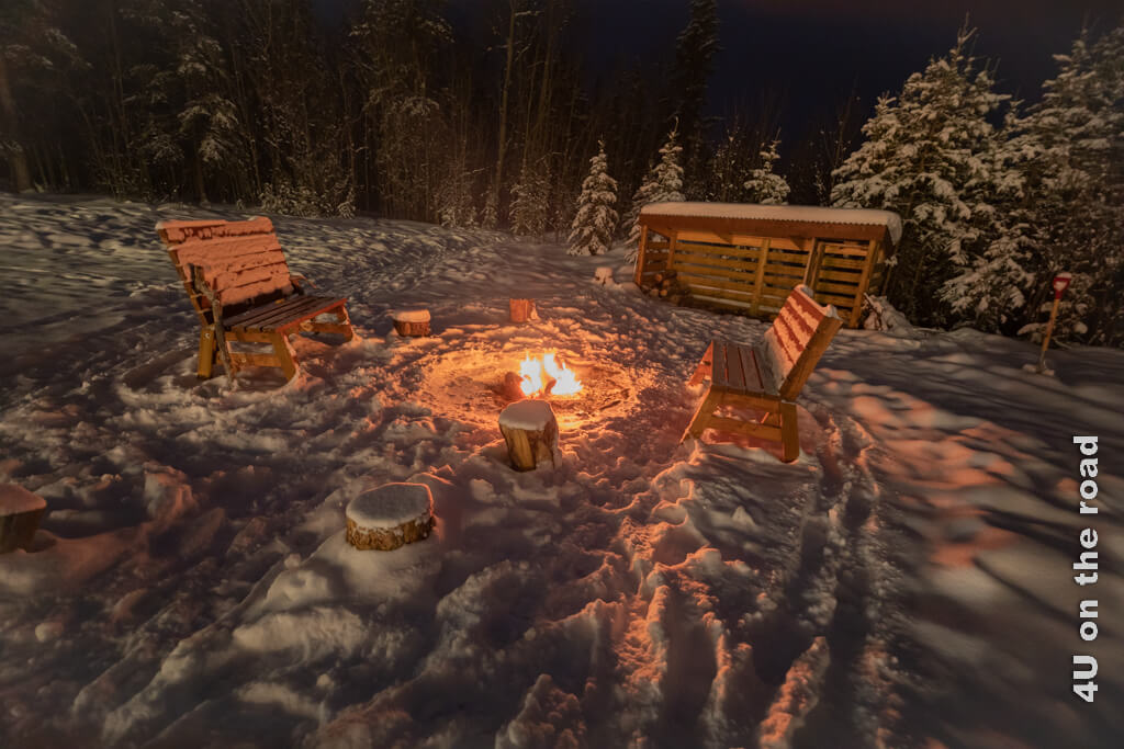 Ein Lagerfeuer in der tief verschneiten Landschaft Kanadas steht für Wärme und Kälte und ganz viel Abenteuer auf diesem unglaublichen Roadtrip nach Kanada