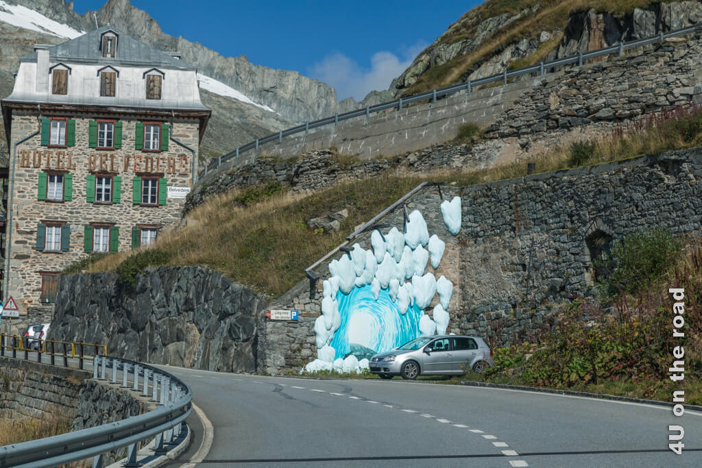 Das Hotel Belvedere steht direkt an der Strasse. Ein Schild wirbt für die Eisgrotte im Rhone Gletscher.