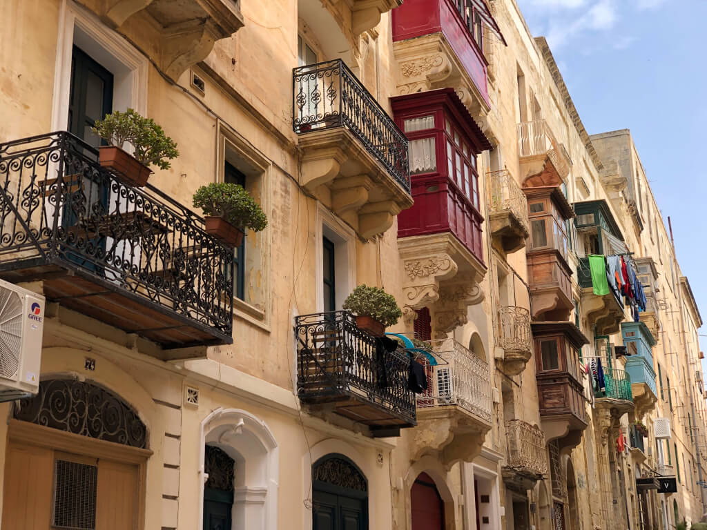Ein Strassenzug schöner alter Häuser mit Balkonen mit schmiedeeisernen Geländern ziert das Bild, welches den Adventskalenderbeitrag zu Valletta illustriert.