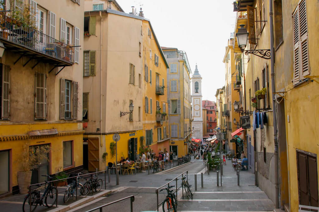 Menschen sitzen in den Cafés und bummeln durch die Strasse mit ihren Läden in der Altstadt von Nizza