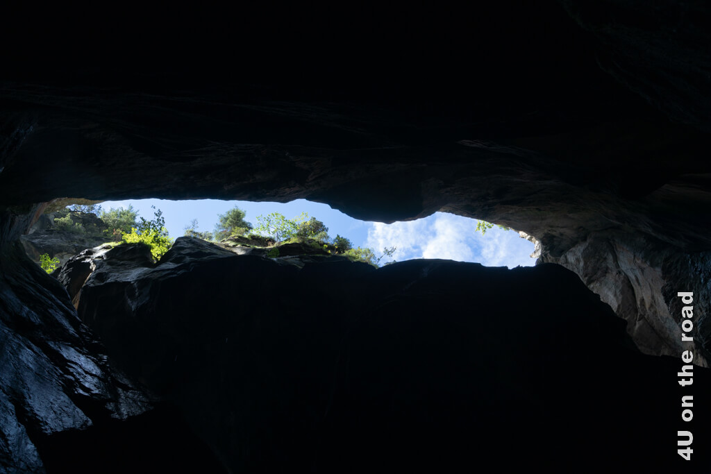 Eine schmale Felsspalte zeigt blauen Himmel und grüne Bäume, während im Berginneren die Trümmelbachfälle tosen.