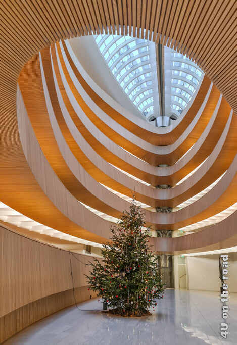 Ein Oval mit Rängen und von einem Glasdach überspannt. Einzig ein geschmückter Tannenbaum bietet dem Auge halt. Diese Bibliothek gehört zu den Zürich Tipps, die du dir unbedingt anschauen solltest.
