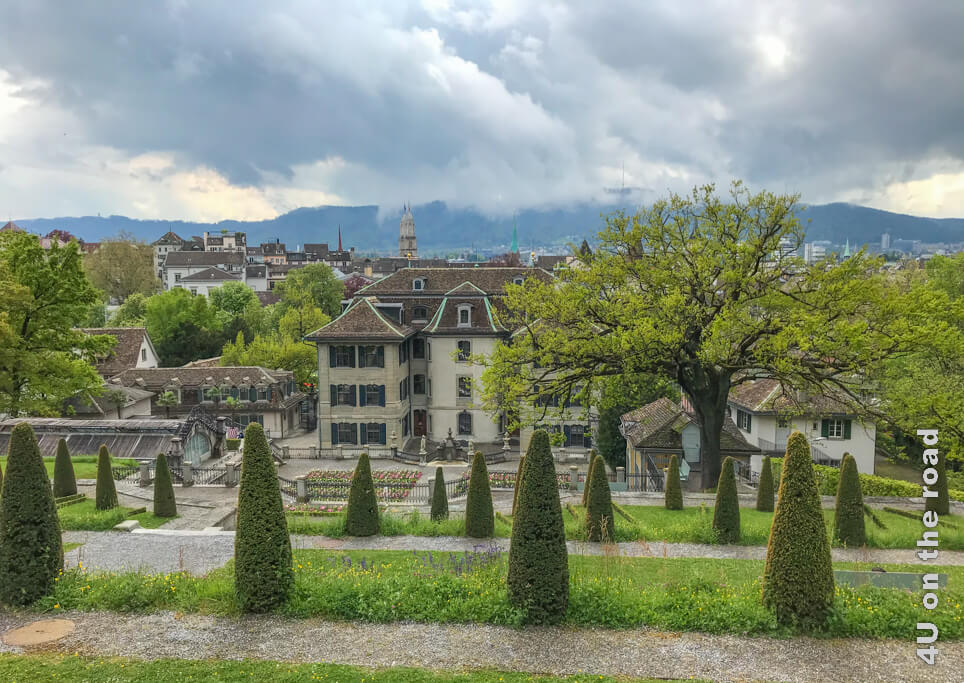 Blick von oben über den Rechberg Park im Frühling. Allerdings kann man den Uetliberg in den Wolken nur ahnen. Der Park ist ein besonderer Ort in Zürich, wo man die Ruhe auf einer der vielen Parkbänke geniessen kann.