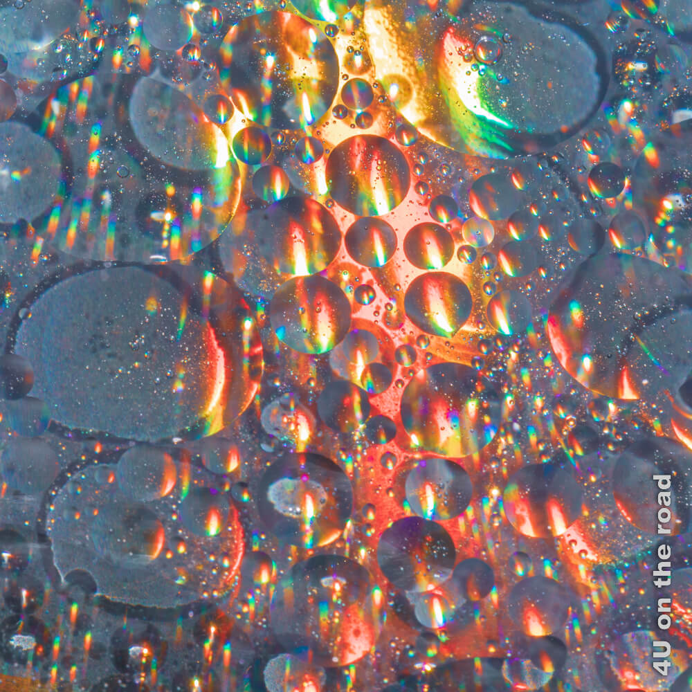 Die sich in einer CD spiegelnde Sonne von Wassertropfen und Öl in eine eigene Landschaft verwandelt.