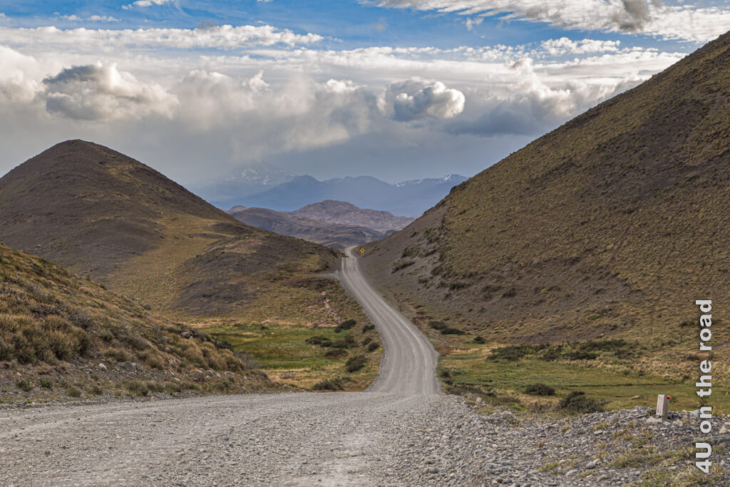 Die Strasse durch den Nationalpark Torres del Paine zerschneidet die Landschaft aus Hügeln.