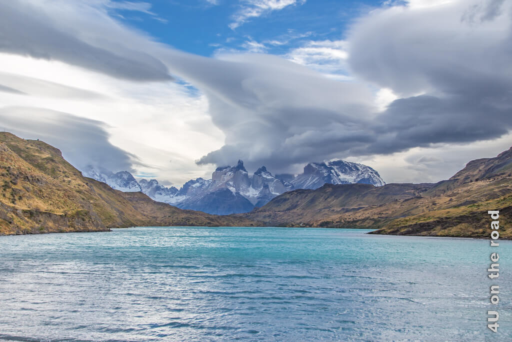Das hellblaue Wasser, dramatische Wolken und blauer Himmel und das Torres del Paine Bergmassiv. 