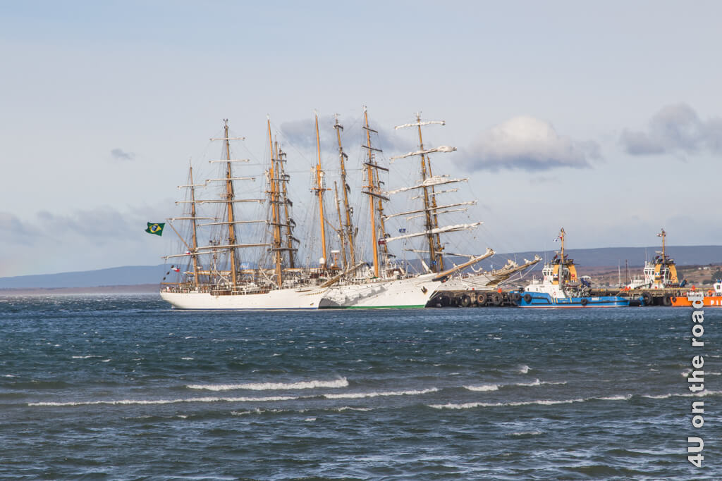 Vier Segelschiffe haben im Hafen festgemacht. Die Flagge Brasiliens flattert im Wind.