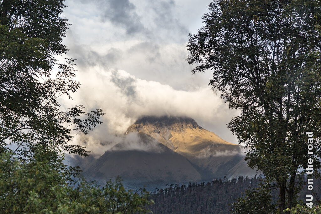 Der Vulkan Cayambe im Licht der untergehenden Sonne. Sein Gipfel ist aber in den Wolken versteckt.