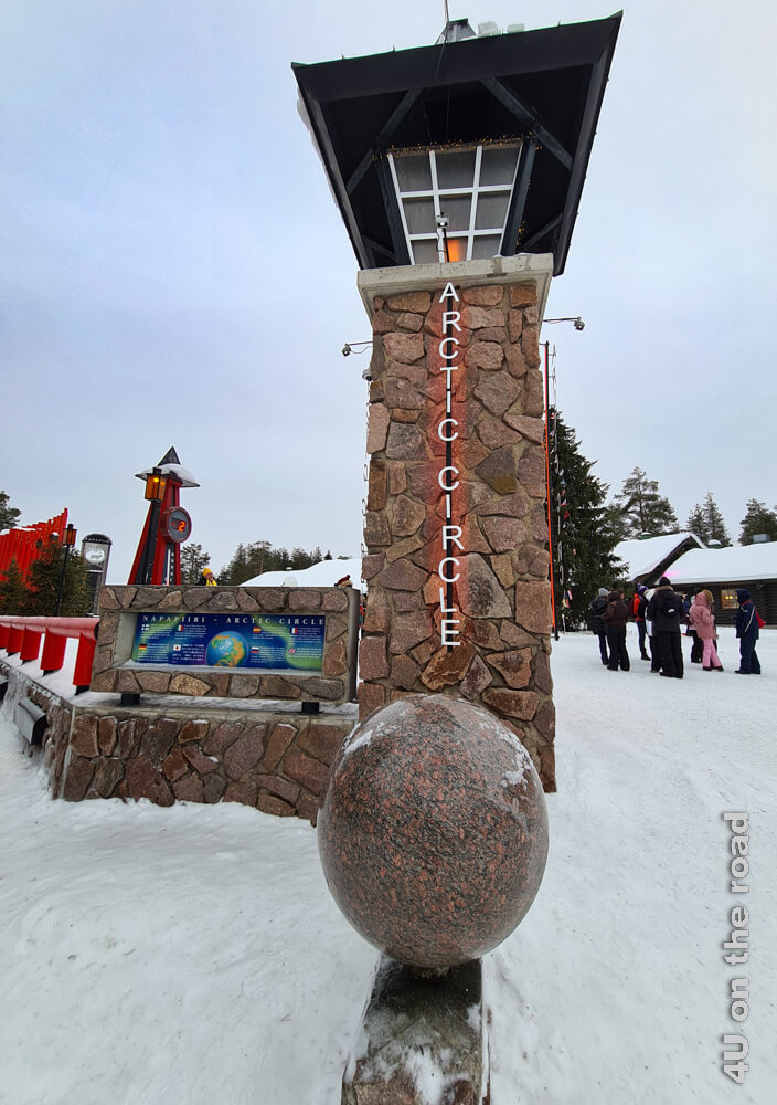 Das Denkmal für den Polarkreis in Rovaniemi im Weihnachtsmanndorf besteht aus einem Turm und einer Weltkugel und Erklärungen in mehreren Sprachen