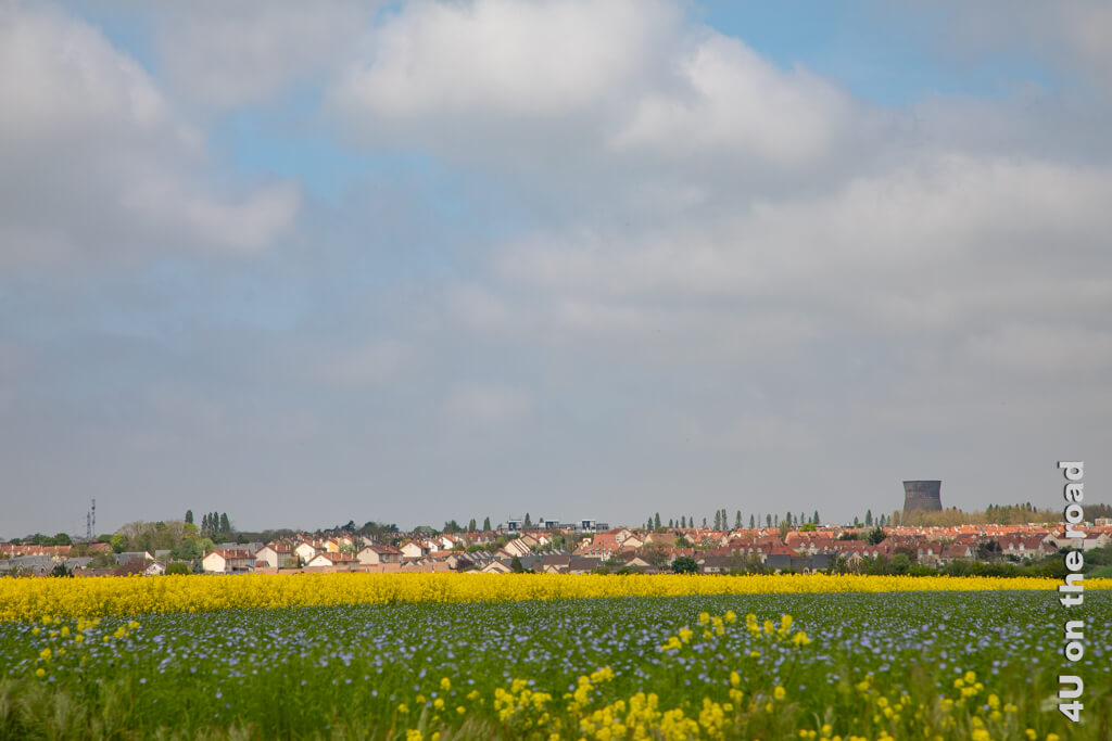 Gelb leuchtet der Raps und die ersten zartblauen Leinblüten sind offen. Hinter den Feldern duckt sich ein Dorf im Schatten eines alten Wasserturms - auf dem Weg zum Abtei Hambye.