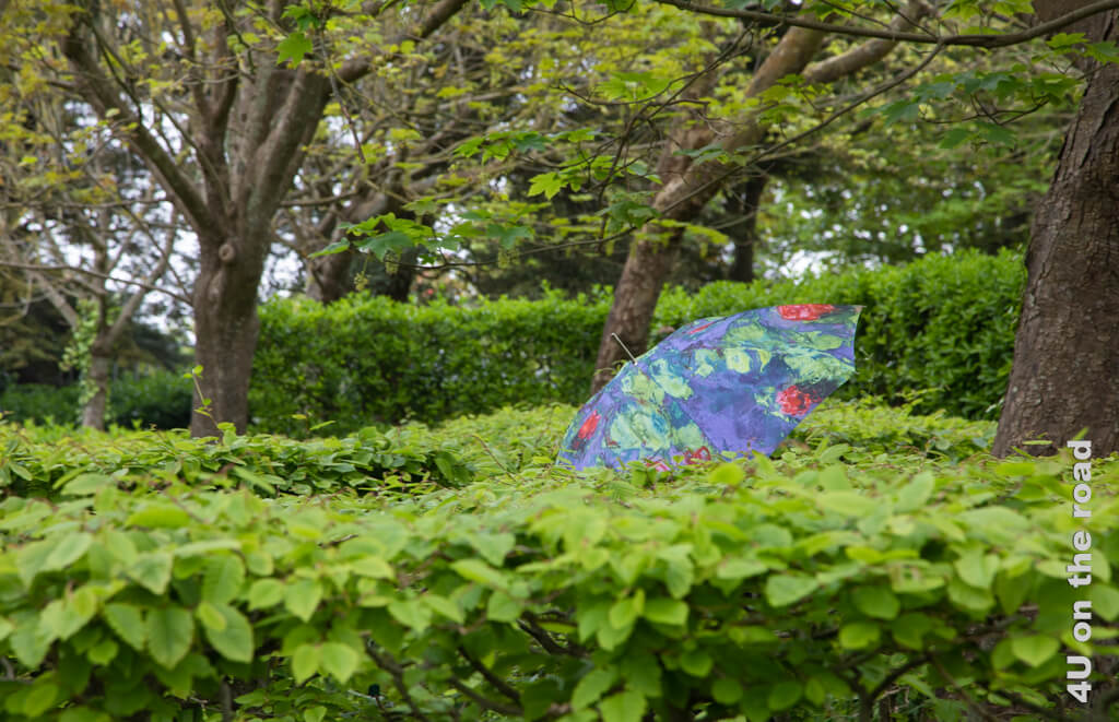 Monet's Regenschirm wandert durch das Grün in Dior's Garten in Granville.