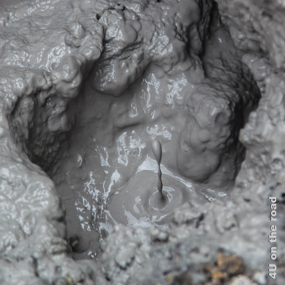 Hier springt eine kleine Schlamm-Fontaine in einem Loch mit viel flüssigem Schlamm nach oben.