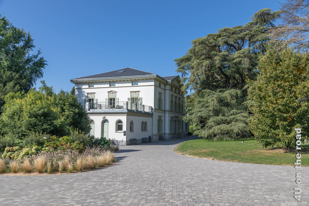 Die Villa Manoir de Ban ist ein weisses Herrenhaus umgeben von wunderschönen alten Bäumen und grossen Rasenflächen.