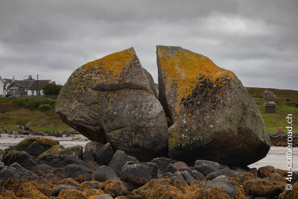 Ein riesiger Felsbrocken wie vom Blitz getroffen, liegt in zwei Hälften geteilt am Hafen von Iona.