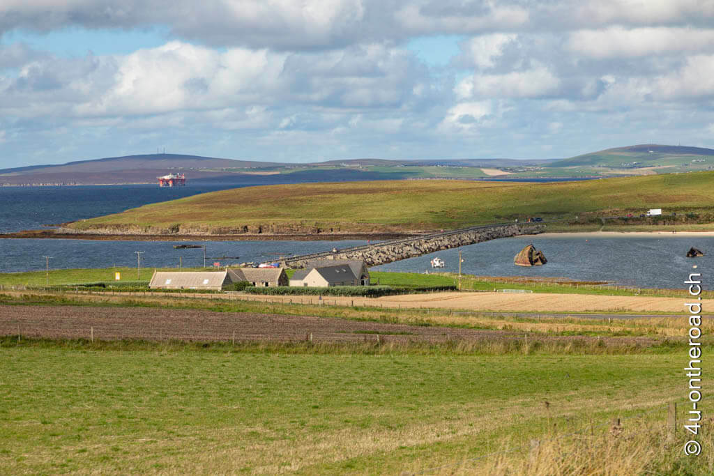 Eine der Churchill Barrieren. Zwischen zwei Inseln wurde die Wasserverbindung durch Felsbrocken und tonnenschwere Betonteile unterbrochen. Roadtrip durch Schottland mit dem Wohnmobil - Orkney Inseln