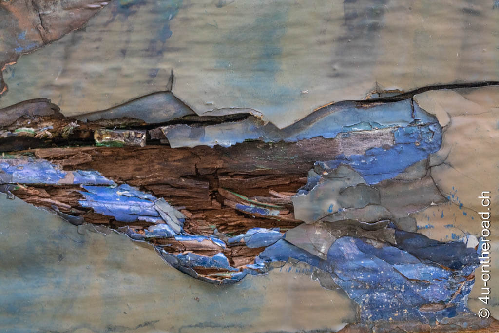 Bröckelnde blaue Farbe und gesplittertes Holz wie aus der Hand eines Künstlers.