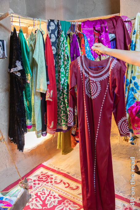 Ein rotes Kleid ist aufwändig mit Perlen bestickt. Museum Bait al Safah, al Hamra