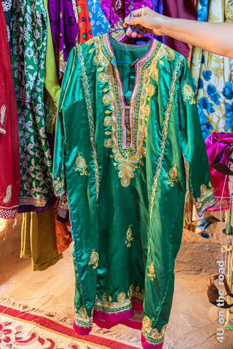 Ein grünes Kleid aus einem glänzenden Stoff ist aufwändig bestickt. Museum Bait al Safah